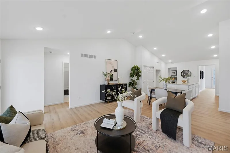 Vaulted ceiling, recessed lighting, LVP flooring, white walls, and an open-concept layout — 9023 Wilkie Station Street, St Charles, MO 63301