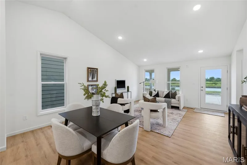 Vaulted ceilings in an open-concept living area with recessed lighting, LVP flooring, and multiple windows — 9023 Wilkie Station Street, St Charles, MO 63301