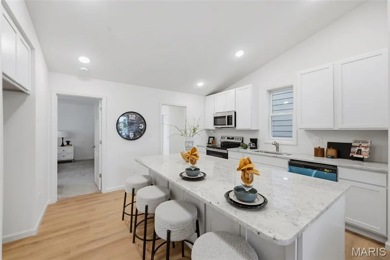 Kitchen featuring white cabinetry, granite countertops, stainless steel appliances — 9023 Wilkie Station Street, St Charles, MO 63301