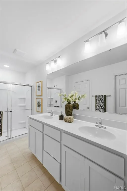 Dual vanity with dual sinks, white cabinetry, and a full-width mirror — 9023 Wilkie Station Street, St Charles, MO 63301