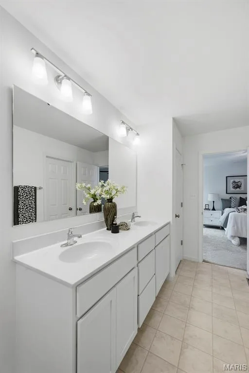 Dual vanity with integrated sinks, white cabinetry, expansive mirror — 9023 Wilkie Station Street, St Charles, MO 63301
