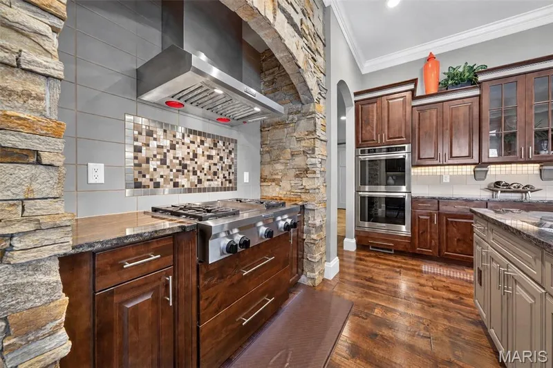 Arched stone alcove for 4 burner gas cooktop with center griddle and range hood — 2000 Diehr Road, Wentzville, MO 63385