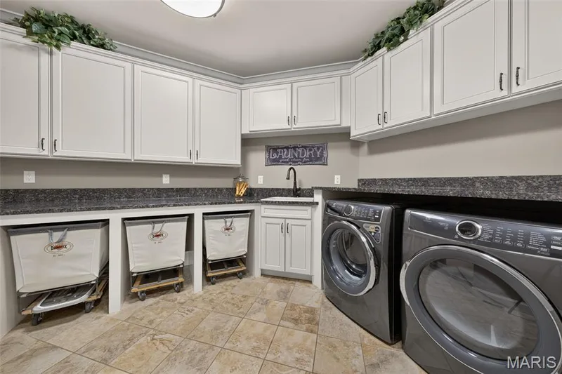 Main floor laundry room with utility sink and granite counters with openings for laundry carts — 2000 Diehr Road, Wentzville, MO 63385