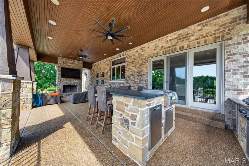Outdoor kitchen with granite island, sink and pull out trash bins — 2000 Diehr Road, Wentzville, MO 63385