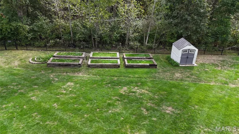 Tree lined backyard with raised garden bed area — 2000 Diehr Road, Wentzville, MO 63385