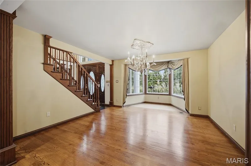 Hardwood flooring, bay window, chandelier, and a wood staircase with balusters — 76 River Valley Drive, Chesterfield, MO 63017