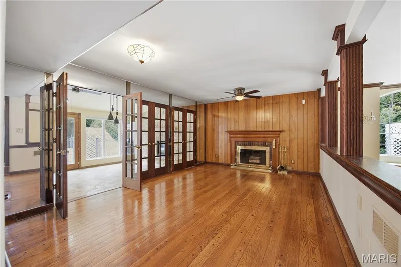 Wood flooring throughout, a wood-paneled wall, and a fireplace with a wood mantle — 76 River Valley Drive, Chesterfield, MO 63017