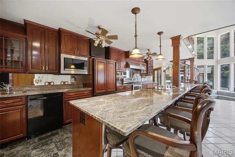 Long breakfast bar with stone countertop, and pendant lighting — 76 River Valley Drive, Chesterfield, MO 63017