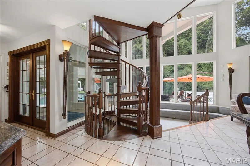 Hardwood spiral staircase, expansive wall of windows, tile flooring, glass French doors, and built-in wall sconces — 76 River Valley Drive, Chesterfield, MO 63017