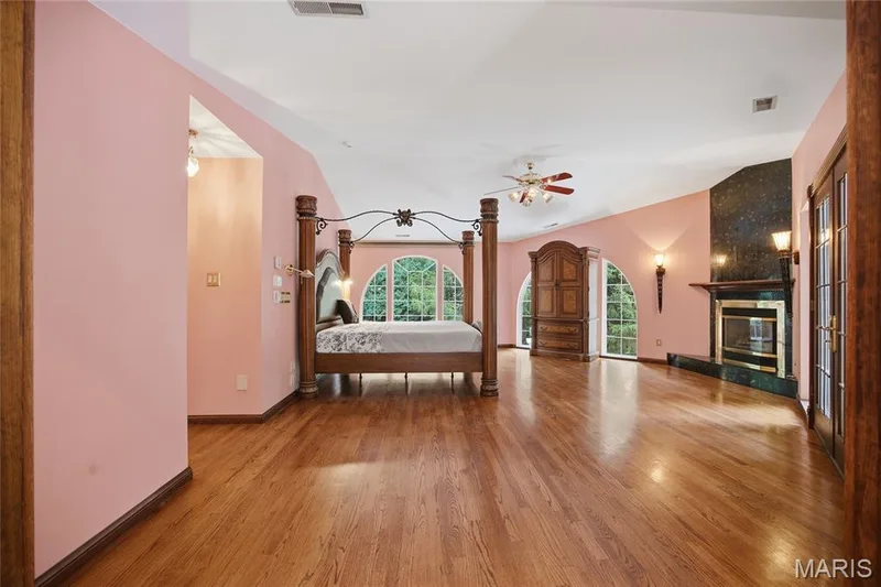 Vaulted ceiling, hardwood flooring, three arched windows, built-in fireplace, and double french doors — 76 River Valley Drive, Chesterfield, MO 63017