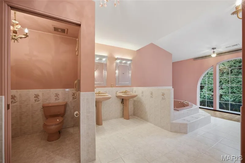 Dual pedestal sinks with individual mirrors, tiled flooring, and a built-in step-up tub — 76 River Valley Drive, Chesterfield, MO 63017