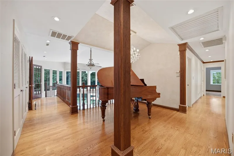 Hardwood flooring throughout, recessed lighting, decorative wood columns, showcase the grand piano overlooking the main level — 76 River Valley Drive, Chesterfield, MO 63017