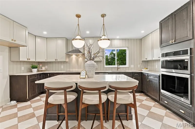 New Two-tone custom cabinetry, quartz countertops, stainless steel appliances, central island with seating, pendant lighting, shiplap backsplash and checkered tile flooring — 621 Claymont Estates Drive, Chesterfield, MO 63017