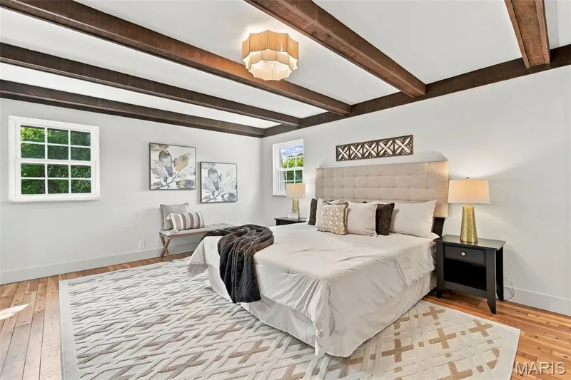 Primary Bedroom with exposed ceiling beams, new windows, hardwood flooring, and a decorative ceiling light fixture. On-suite bathroom and walk-in closet — 621 Claymont Estates Drive, Chesterfield, MO 63017