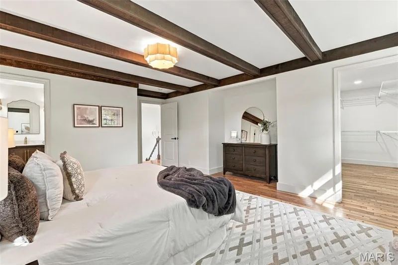 Exposed wood beam ceiling, central lighting fixture, wood-finish flooring, white walls, and a large walk-in closet — 621 Claymont Estates Drive, Chesterfield, MO 63017