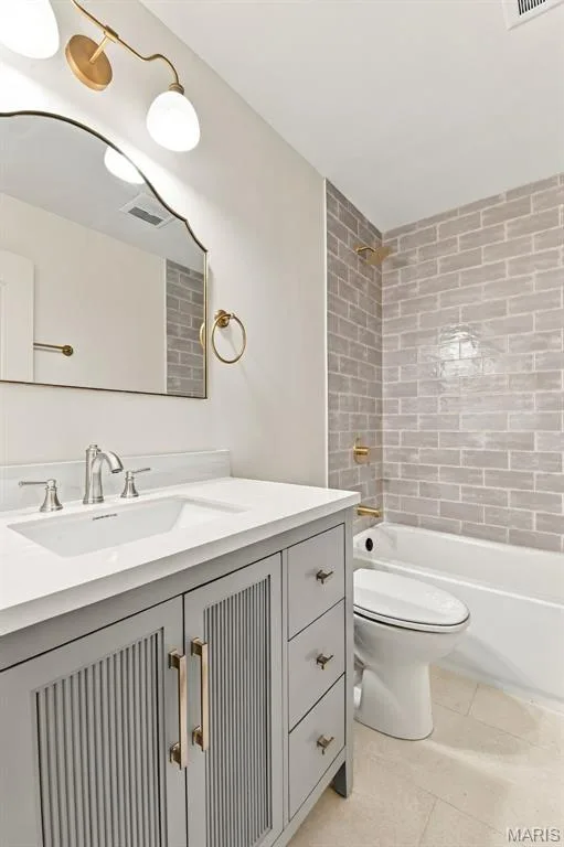 Bathroom featuring a gray vanity with integrated sink, white countertop, and gold-toned hardware — 621 Claymont Estates Drive, Chesterfield, MO 63017