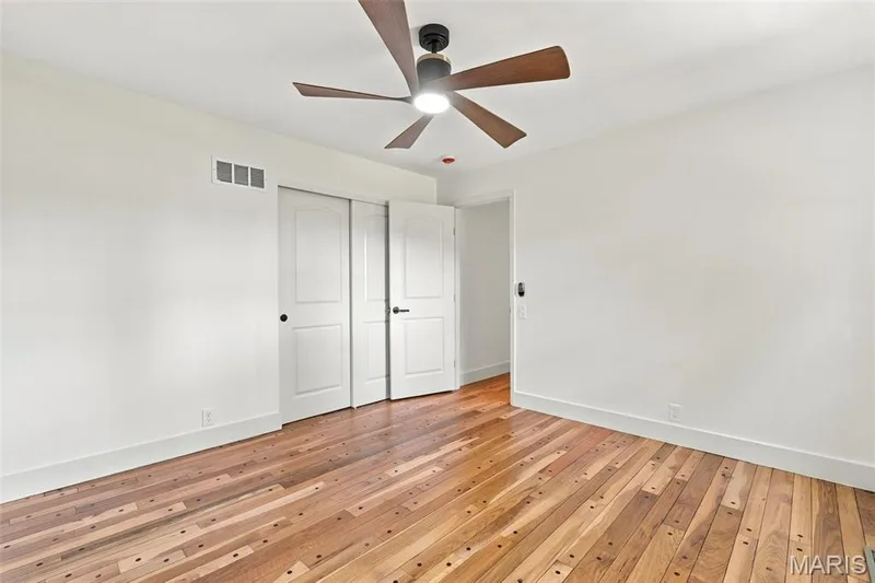 Wood-finish flooring, ceiling fan with integrated lighting, and white walls — 621 Claymont Estates Drive, Chesterfield, MO 63017