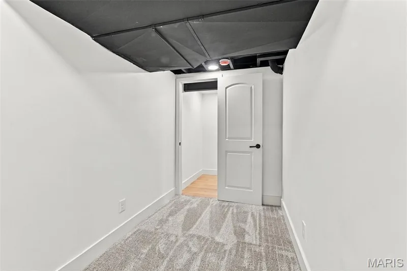 Exercise or Play Room White paneled door with black hardware, exposed black ceiling, and gray patterned carpet — 621 Claymont Estates Drive, Chesterfield, MO 63017