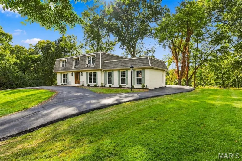 Gambrel roofline with dormer windows, light-colored siding, and contrasting shutters — 621 Claymont Estates Drive, Chesterfield, MO 63017