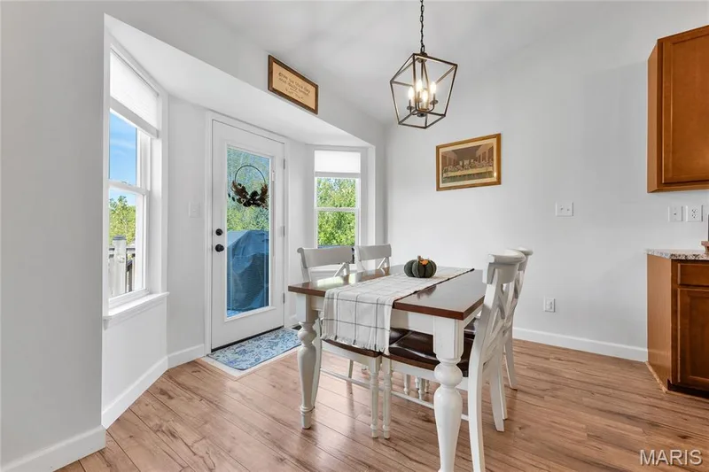 Bay window with multiple windows, wood-finish flooring, white walls, and a multi-light geometric pendant fixture — 5507 Dressel Drive, Cottleville, MO 63304
