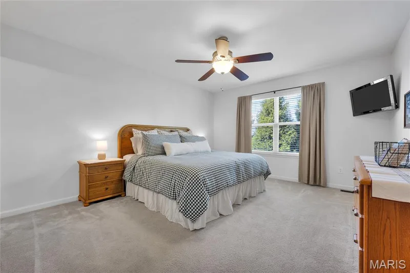 Neutral wall paint, ceiling fan with integrated lighting, large window with blinds, and wall-to-wall carpeting — 5507 Dressel Drive, Cottleville, MO 63304