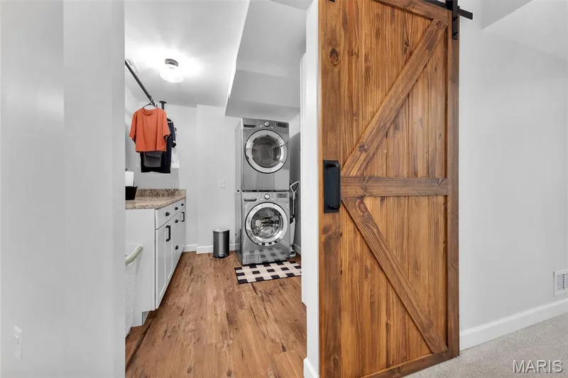 Laundry area featuring wood-finish flooring and a wood barn door — 5507 Dressel Drive, Cottleville, MO 63304