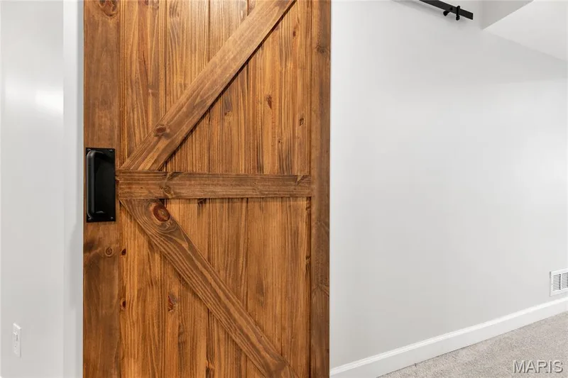 Wood-finish barn door with black hardware — 5507 Dressel Drive, Cottleville, MO 63304