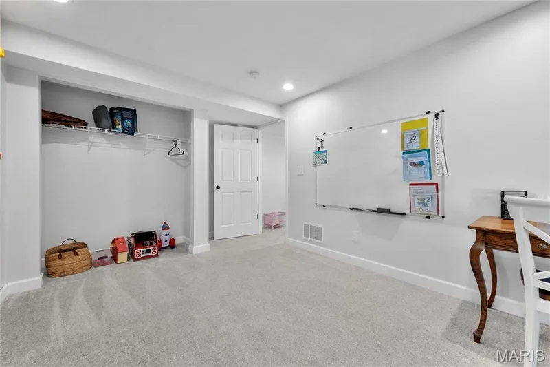 Carpeted room with recessed lighting, an open closet featuring wire shelving, and a white paneled door — 5507 Dressel Drive, Cottleville, MO 63304
