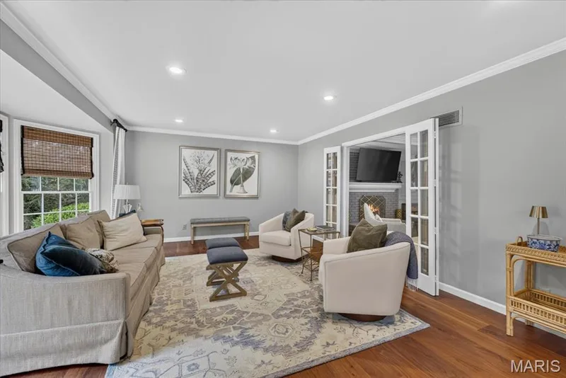 Traditional living room with french doors, rich wood flooring and crown molding — 1165 Templeton Place, Chesterfield, MO 63017