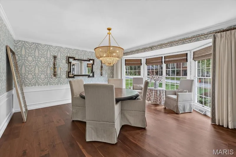 The dining room has designer wallpaper, a pretty chandelier and bay windows for extra seating. — 1165 Templeton Place, Chesterfield, MO 63017