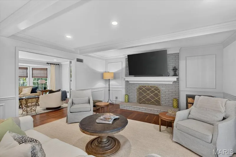 A newer gas fireplace and view of living room through french doors in the family room — 1165 Templeton Place, Chesterfield, MO 63017