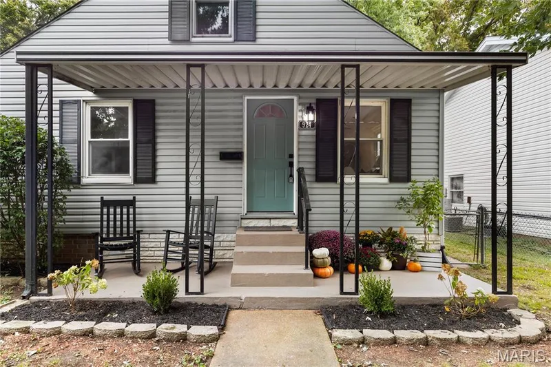 Covered front porch with gray siding, black shutters, and a teal entry door — 924 N Benton Avenue, St Charles, MO 63301