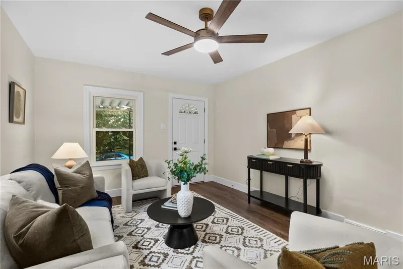 Wood-finish flooring, a ceiling fan with integrated lighting, a white paneled entry door with an arched glass insert, and a console table with lower shelving — 924 N Benton Avenue, St Charles, MO 63301
