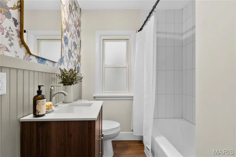 Vanity with white countertop, chrome faucet, and wood-finish cabinetry — 924 N Benton Avenue, St Charles, MO 63301