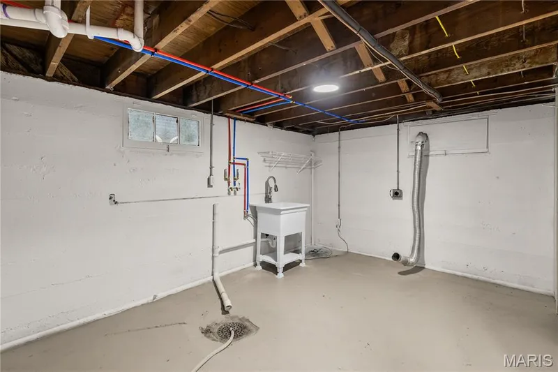 Painted concrete floor, utility sink, exposed ceiling joists, overhead lighting, and window — 924 N Benton Avenue, St Charles, MO 63301