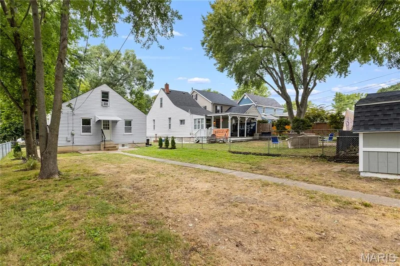 Expansive yard featuring mature trees, a detached storage shed, and a concrete pathway — 924 N Benton Avenue, St Charles, MO 63301