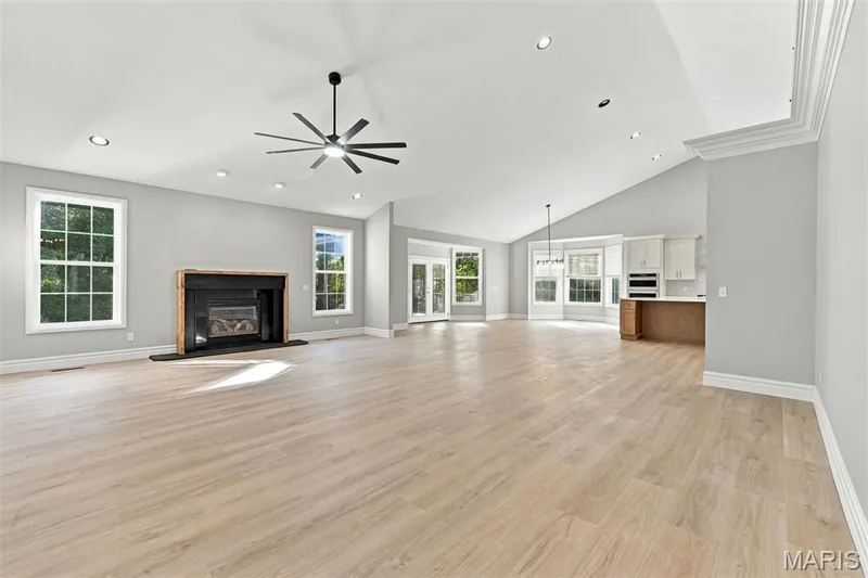Vaulted ceilings with recessed lighting, luxury vinyl plank flooring, a built-in fireplace, and a contemporary ceiling fan — 1580 Madre Drive, Foristell, MO 63348