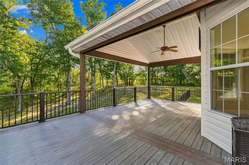 Expansive covered deck with composite decking, vaulted ceiling, and built-in ceiling fan — 1580 Madre Drive, Foristell, MO 63348