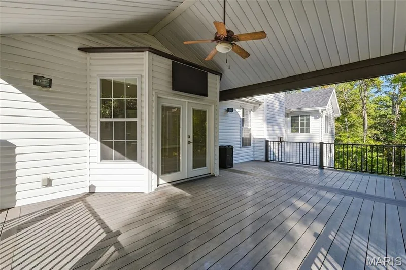 Expansive covered deck featuring composite decking, a ceiling fan, and French doors leading indoors — 1580 Madre Drive, Foristell, MO 63348
