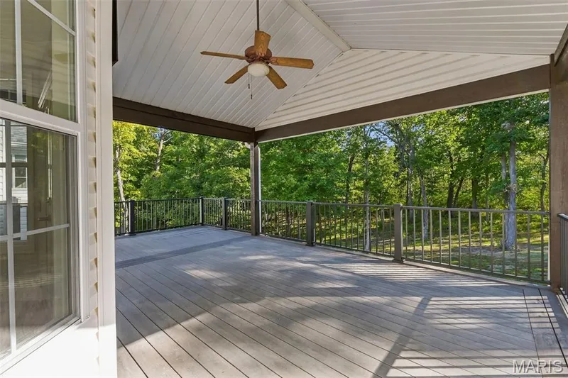 Expansive vaulted covered deck with composite decking, decorative railings, and a ceiling fan — 1580 Madre Drive, Foristell, MO 63348
