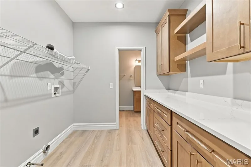 Recessed lighting, vinyl plank flooring, wire shelving, wood cabinetry, floating shelves, and quartz countertops.  Dryer can be electric or propane hook ups — 1580 Madre Drive, Foristell, MO 63348