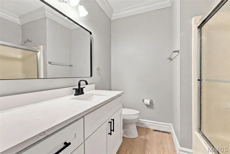 White vanity with black hardware, white countertop, rectangular undermount sink, and black faucet — 1580 Madre Drive, Foristell, MO 63348