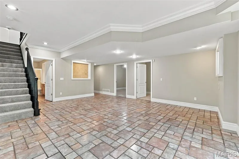 Expansive open space with multi-tone tile flooring, recessed lighting, and crown molding — 1580 Madre Drive, Foristell, MO 63348
