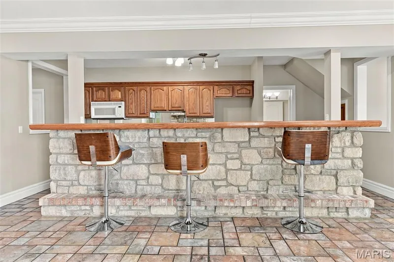 Stone-clad bar with a wood countertop, brick base, and tiled flooring — 1580 Madre Drive, Foristell, MO 63348