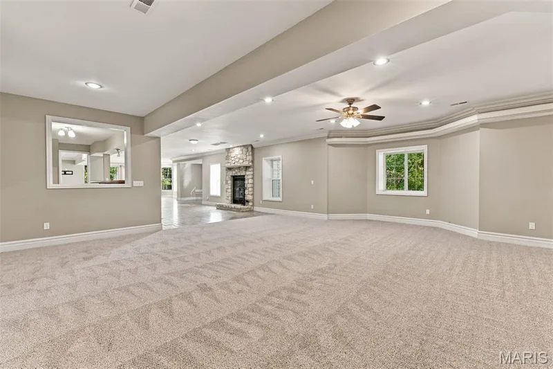 Expansive carpeted area with recessed lighting, crown molding, a ceiling fan, and multiple windows — 1580 Madre Drive, Foristell, MO 63348