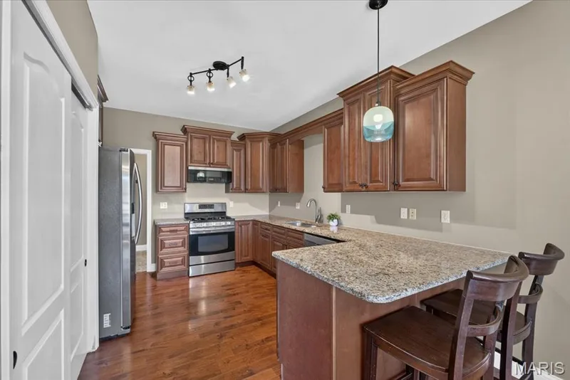 The updated kitchen features 42-inch cabinetry, granite countertops, and stainless steel appliances — 2265 Mette Road, Wentzville, MO 63385