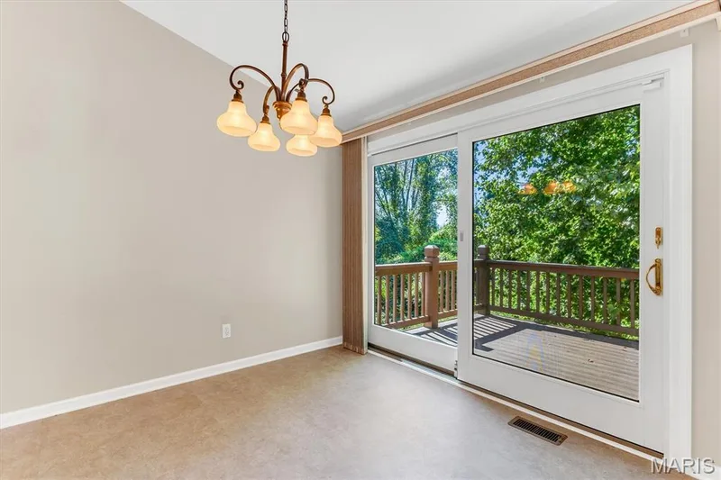 Vaulted breakfast room has oversized slider door to near-private deck. — 18 Country Bluff Court, St Charles, MO 63301