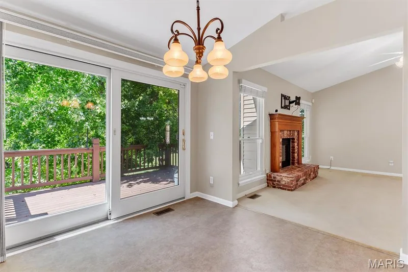 View from your breakfast room to tree-lined view & living room fireplace. — 18 Country Bluff Court, St Charles, MO 63301