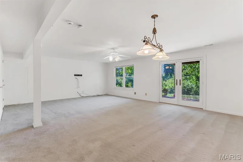 Lower level walk-out to brick patio has egress window & custom lighting. — 18 Country Bluff Court, St Charles, MO 63301