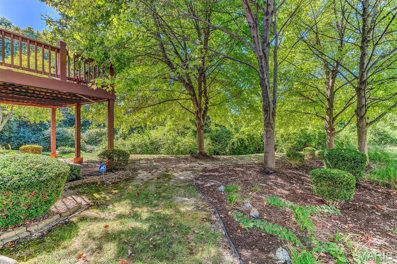 Oversized deck surrounded by mature trees and landscaping. — 18 Country Bluff Court, St Charles, MO 63301